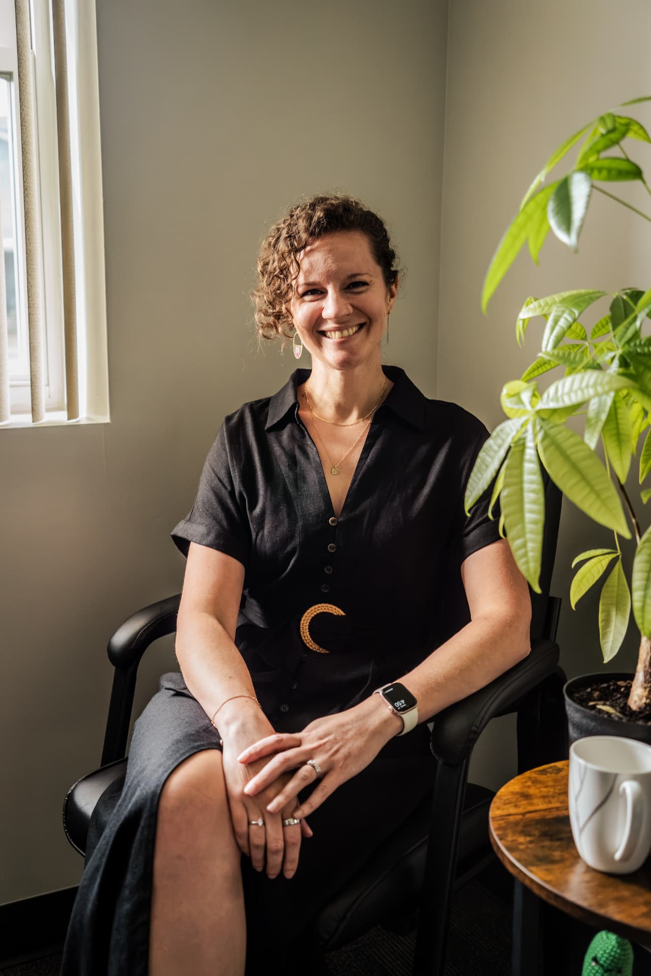 Veronica seated in a therapy office with a houseplant nearby